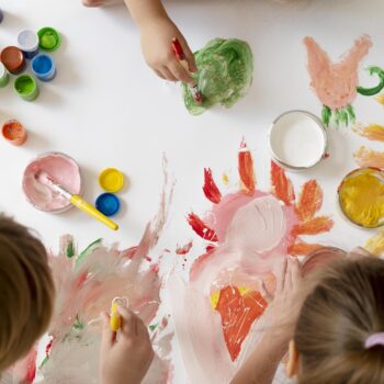 cerrar-ninos-pintando-pinceles-juntos