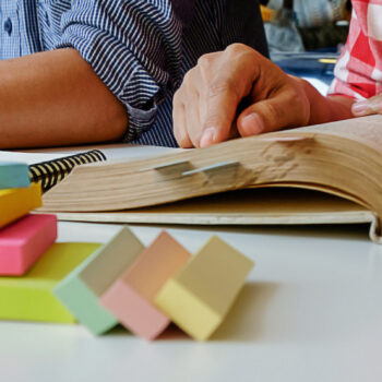 Education concept. Students studying and brainstorming campus concept. Close up of students discussing their subject on books  textbooks and writing to notebook. Seclective focus.